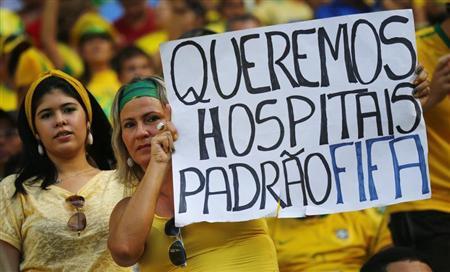 Uma manifestante segura cartaz durante partida do Brasil contra o México pelo grupo A da Copa das Confederações, em Fortaleza